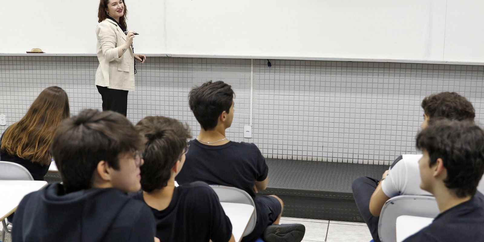 Professora conversa com alunos em um colégio de Brasília, em outubro de 2024. A Prova Nacional Docente avalia quem está concluindo a licenciatura para dar aula na educação básica. (Foto de arquivo)