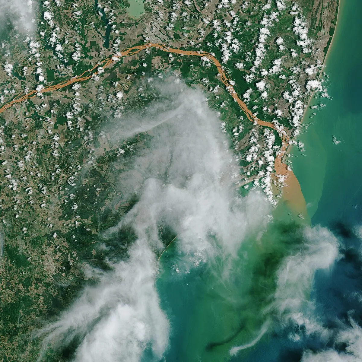 Imagem de satélite da NASA mostra a pluma de rejeitos do rompimento da barragem de Fundão alcançando o Atlântico pela foz do Rio Doce, no fim de 2015.